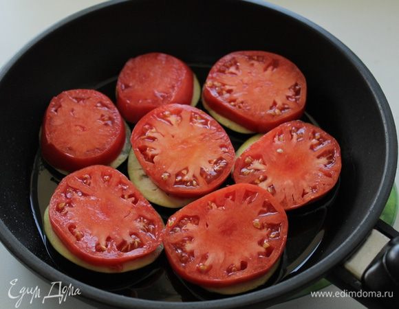 Баклажаны режем на медальоны толщиной около 1 см, выкладываем в один слой в сковороду, помидоры режем так же и выкладываем на баклажаны, накрываем крышкой и готовим на медленном огне 10 минут.