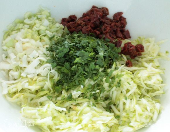 Кабачок натереть на крупной терке,лук-порей,вяленые томаты,зелень нарезать.