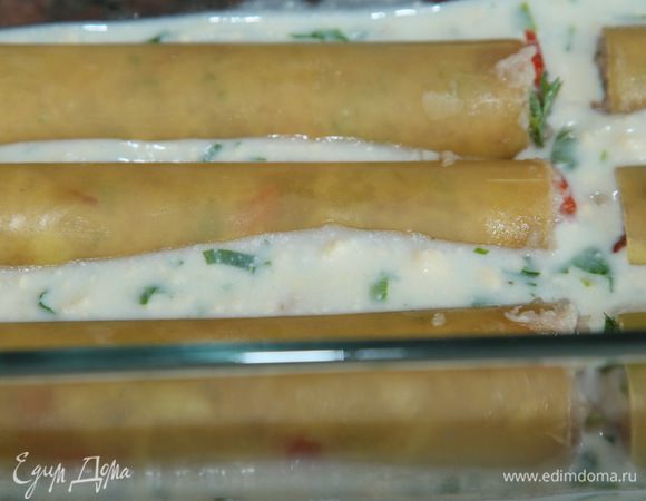 Собираем наше блюдо: на дно формы наливаем соус щедро и выкладываем в один слой каннеллони так, чтобы они друг с другом не соприкасались. 