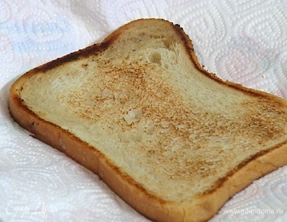 Разогреть в сковороде сливочное и растительное масло и обжарить целый кусок хлеба с двух сторон до румяной корочки, затем выложить на бумажное полотенце.