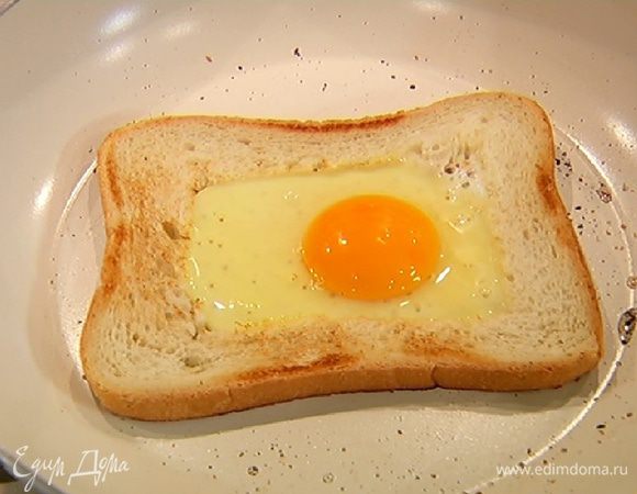 На эту же сковороду, не добавляя масла, выложить второй кусок хлеба, обжарить с двух сторон до румяной корочки, затем разбить в вырезанное окошко яйцо и жарить его до готовности.