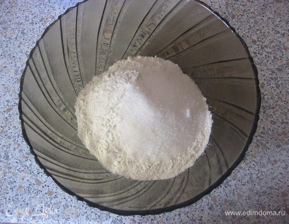 Просеять муку в миску, добавить соль, соду, сахар.
Перемешать и сделать углубление.