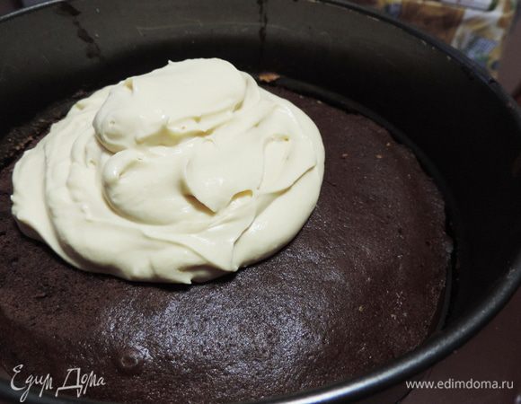 Торт собирать лучше в кондитерском кольце или использовать бортик от разъемной формы. Так он у вас обязательно получится ровным и красивым. На блюдо кладем один корж. Заключаем его в кольцо. Порядок коржей может быть произвольным, у меня первый шоколадный, затем изюм, мак и орехи. Выкладываем сверху примерно 1/4 часть крема.