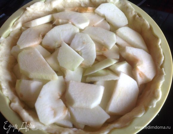 Яблоки очистите, удалите сердцевину, нарежьте тонкими пластинами. Разложите яблоки на тесто.