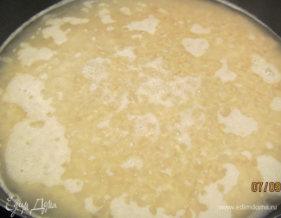 В другой кастрюле растапливаем сливочное масло. Добавляем рис, помешивaем его и даем ему несколько минут пропитаться маслом. Затем вливаем горячую воду, один раз помешаем. Накрываем крышкой и готовим на небольшом огне минут 40 (+-). Рис должен стать мягким и впитать всю жидкость. 
