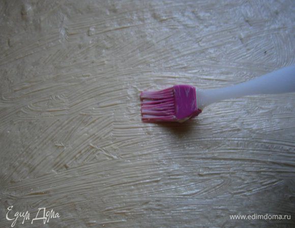 Затем тесто ещё раз раскатать скалкой в тонкий пласт, смазать мягким сливочным маслом.