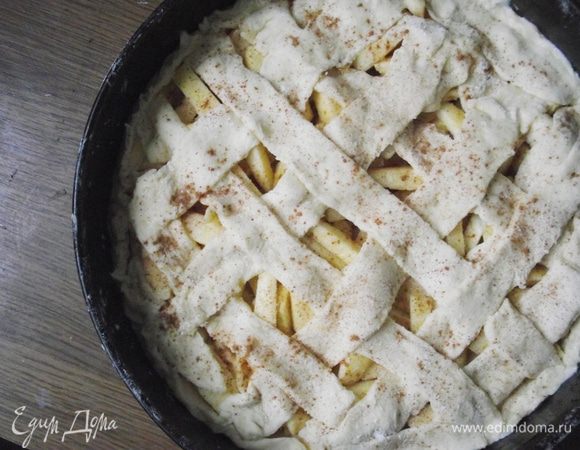 Вторую половину теста раскатать на столе, присыпав немного муки. Разрезать ножом на полоски и сформировать сетку. Накрыть яблочную начинку.