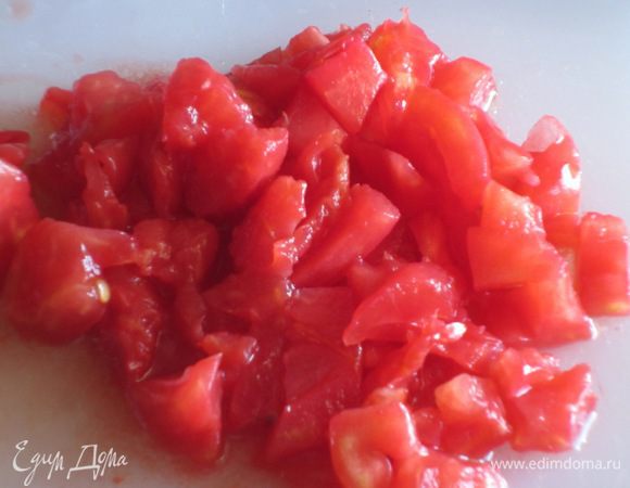 Помидор надрезать крест-накрест и ошпарить кипятком. Снять кожицу и мелко нарезать  мякоть.

