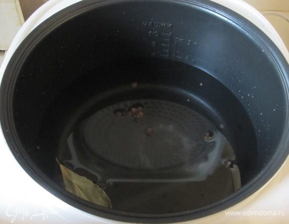 В чашу мультиварки налить воду. Посолить, добавить лавровый лист, черный и душистый перец горошком.