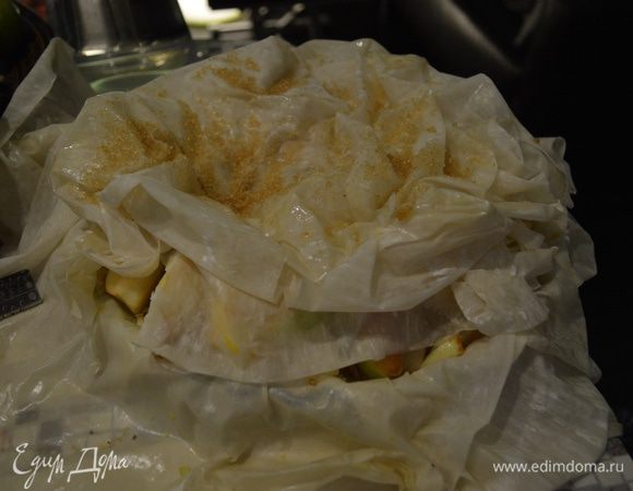 Свисающие края Фило поднимаем и укладываем  на яблоки, не приминая и не разглаживая тесто, напротив, стараясь придать ему естественную помятость. 