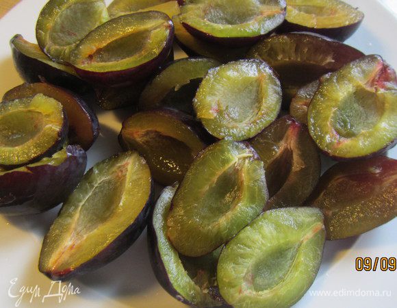 В это время подготовим начинку. Сливы разрезаем напополам и удаляем косточку.

