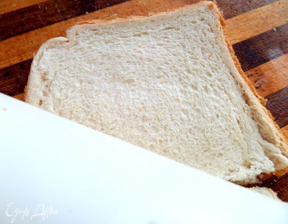 Переворачиваем на доске сыром вниз и плотно раскатываем хлеб скалкой.