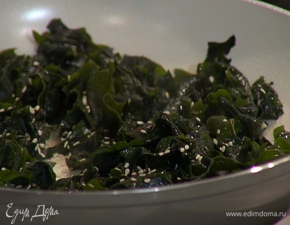 Водоросли слегка отжать (воду сохранить), добавить их в сковороду с чесноком, перемешать и посыпать кунжутными семечками.