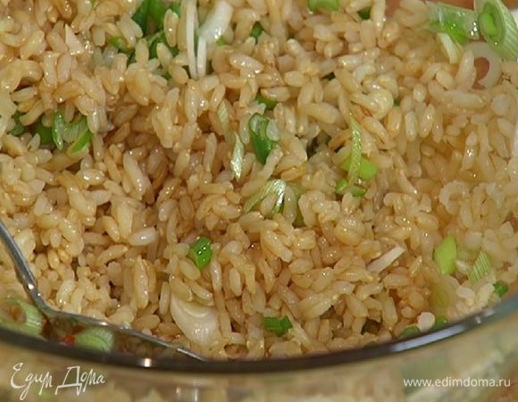 Готовый рис соединить с зеленым луком, полить оставшимся кунжутным маслом, рисовым уксусом, соевым соусом, посыпать подкопченным перцем чили и все перемешать.