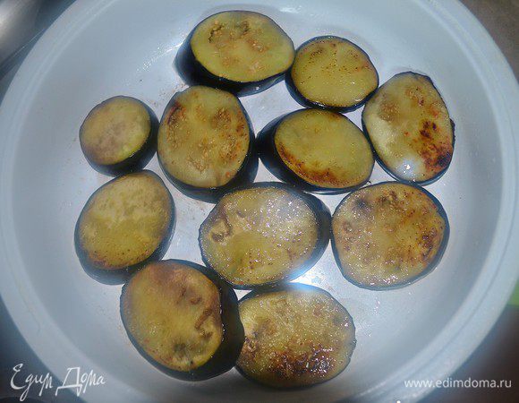 Слегка обжарить кружки баклажанов на растительном масле.