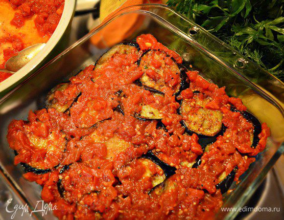 В подготовленную форму выкладываем слоями: кружки баклажан, помидоры... 