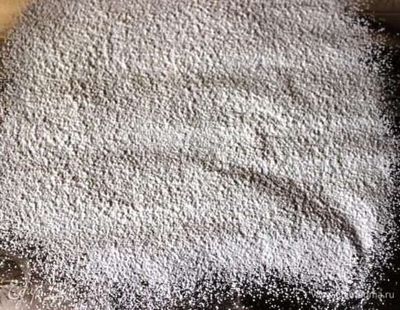 На решетку помещаем пергамент, посыпаем сахарной пудрой (я делала это через сито). Переворачиваем форму с готовым тортом на пергамент. Когда корж остынет, он должен сам выпасть из формы на бумагу.