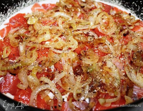 Осторожно вылить на дно 2/3 части теста и ровно распределить его. Поверх теста выложить кусочки рыбы (по-одному, от центра к краю). На рыбу разложить лук. Присыпать солью, перцем и свеженатертым мускатным орехом. Много солить не нужно, поскольку тесто с майонезом, в нем достаточно соли.