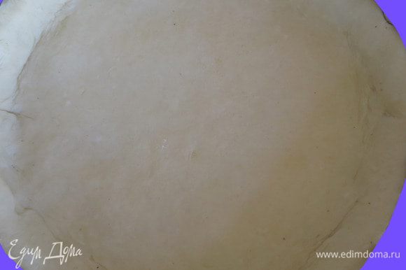 Тесто раскатываем в круглую лепешку, размер которой должен быть чуть больше размера формы. Круглую форму ( 22 см) застилаем пекарной бумагой, смазываем оливковым маслом и распределяем раскатанное тесто, формируя бортики.