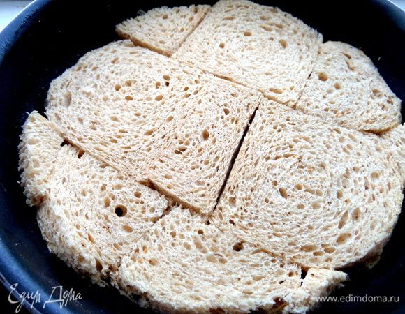 Смазываем форму (22 см) растительным маслом и плотно выкраиваем хлеб,чтобы он образовал корж-основу.