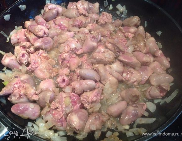 На сковороде с толстым дном обжарьте лук, чеснок, добавьте субпродукты и обжарьте до появления золотистой корочки.