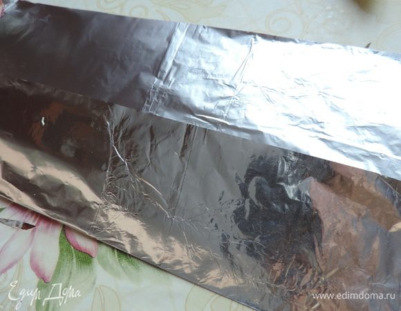 Пока грибы тушатся, а филе маринуется, приготовим одноразовые формочки из фольги. Берем отрезок фольги длинной примерно 50 см. Кладем наш прямоугольник блестящей стороной на стол. Загибаем наверх примерно 1/3 часть большей стороны.