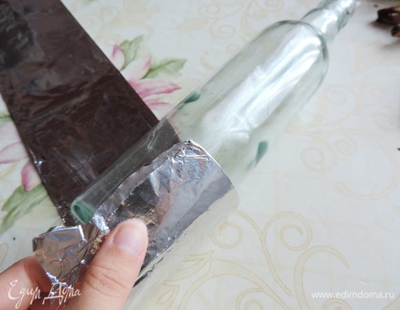 Теперь нам понадобиться предмет правильной цилиндрической формы. Можете воспользоваться круглым стаканом или бутылкой. На край рукава кладем наш выбранный предмет (у меня бутылка). Примерно треть рукава должна снизу выступать за бутылку. 