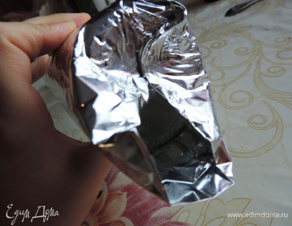 Теперь свободный край фольги загибаем на дно бутылки. Дно должно быть полностью прикрытым, промежутков не оставляйте. Теперь, когда дно формочки сформировано, аккуратно снимаем ее с бутылки.