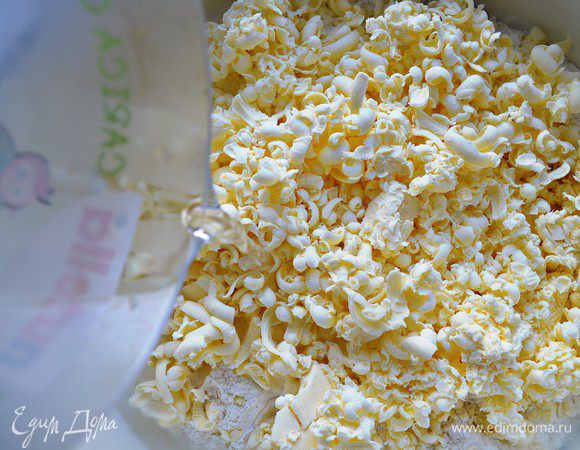 Добавьте охлаждённое сливочное масло. Нарежьте его кубиками или натрите на тёрке.  Смешайте масло с мукой до получения крошки.  Добавьте ледяную воду. 