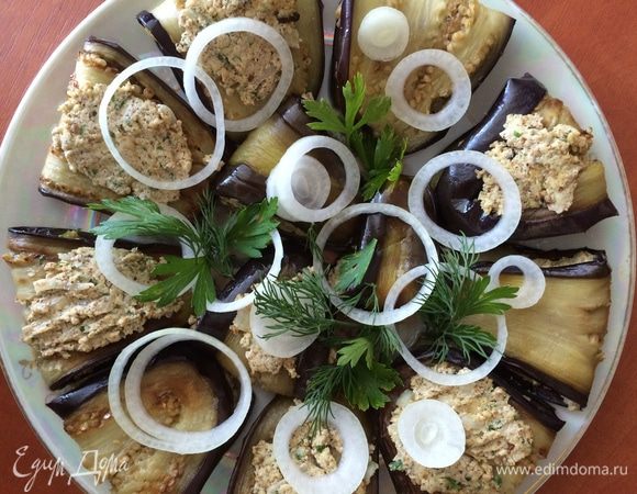 Складываем баклажаны в кастрюльку, отдельные кусочки дополнительно смазываем сверху пастой сациви. Ставим в прохладное место на 2-3 часа, чтобы баклажаны хорошо пропитались.
Сервируем баклажаны на большой плоской тарелке, украсив кольцами лука и веточками петрушки. 
