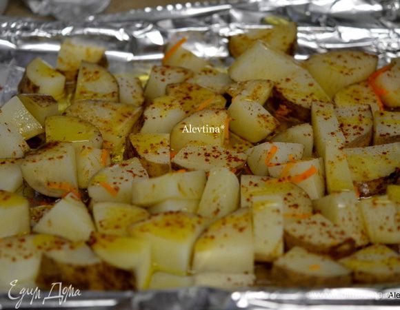 Противень застелить бумагой для выпечки, вылить оливковое масло и поставить в горячую духовку на 5 мин. Затем выложить на горячий противень картофель, перемешать с горячим оливковым маслом. Посолить, посыпать куркумой и паприкой и вернуть в духовку на 1 час.
