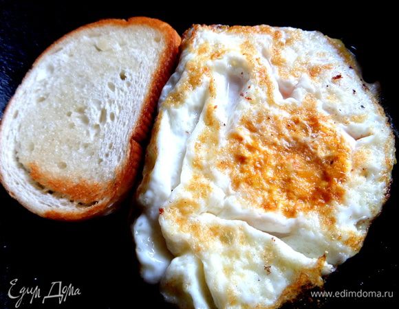 Переворачиваем на лопатке аккуратно и жарим хлеб яйцом вверх. Рядом обжариваем второй кусочек с двух сторон.