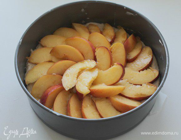 Форму  20-22 см смазать сливочным маслом, посыпать мукой и выложить половину теста.
Нектарины порезать и выложить поверх теста.