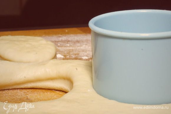 Раскатать готовое тесто и вырезать кружки круглой формочкой для печенья или с помощью стакана. Достаточно раскатать тесто до толщины 1-1,5 см., так как при жарке они очень сильно увеличиваются в объёме. Оставить пончики для расстойки на один час.