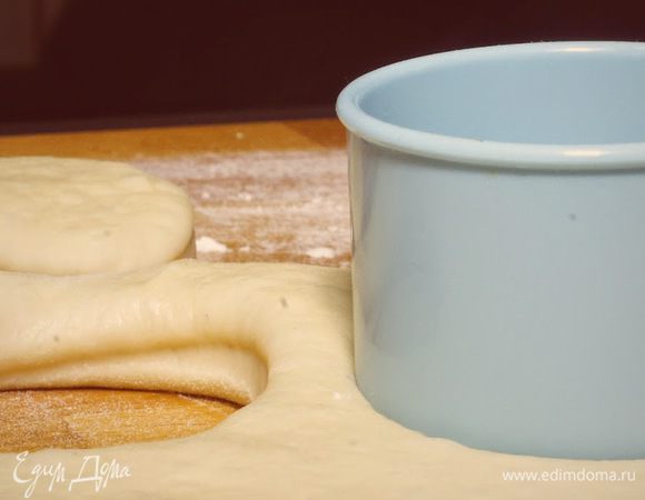 Раскатать готовое тесто и вырезать кружки круглой формочкой для печенья или с помощью стакана. Достаточно раскатать тесто до толщины 1-1,5 см., так как при жарке они очень сильно увеличиваются в объёме. Оставить пончики для расстойки на один час. 