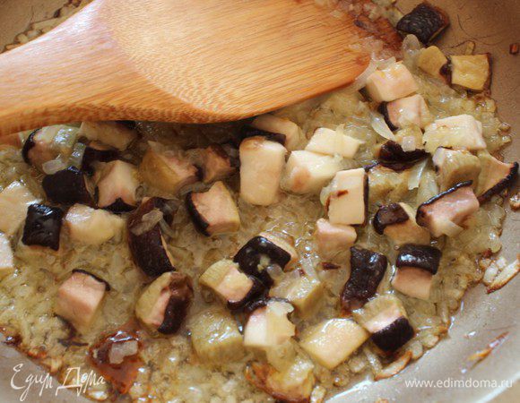 Лук и зубчик чеснока мелко порубить и слегка обжарить на оливковом масле до золотистого цвета, добавить порубленные грибы и жарить до тех пор, пока не выпарится лишняя жидкость.