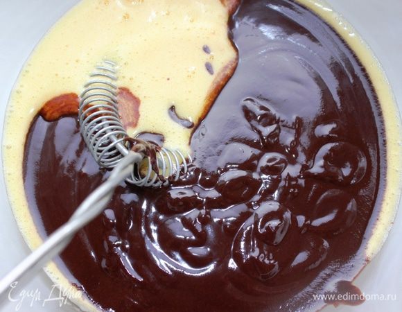 Тем временем отделить белки от желтков. Взбить желтки в пушистый крем и смешать их с охлажденной шоколадной массой.