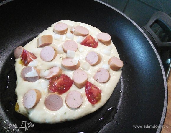 Сосиски порезать в расчете 1/1, также помидор. На разогретое масло вылить тесто ( 1суповой паломник на 1пан кейк), повтыкать))) сосиски, помидоры. 