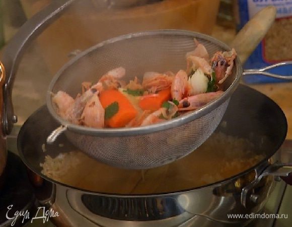 Готовый бульон из панцирей процедить, влить в сковороду с рисом и готовить, не накрывая крышкой, около 20 минут до готовности риса. Если бульон выпарится, влить немного горячей воды или белого сухого вина.