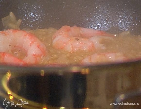 В готовый рис добавить очищенные креветки, перемешать и дать им прогреться.