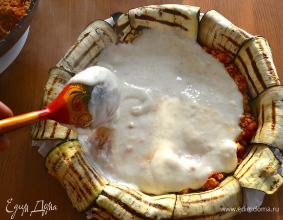 Сверху половину соуса бешамель. Затем снова слой оставшегося фарша и бешамель. Сверху посыпать все тертым пармезаном.