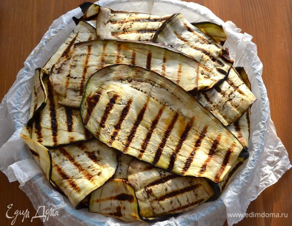 Закрыть - "упаковать" - начинку, завернув к центру баклажаны. Я сверху положила еще два ломтика, чтобы полностью закрыть начинку. Поставить запекаться в разогретую духовку на 40 минут. Тем временем для украшения готового блюда вымыть и очистить от кожицы помидоры, предварительно обдав кипятком! Удалить семена и нарезать маленькими кубиками.