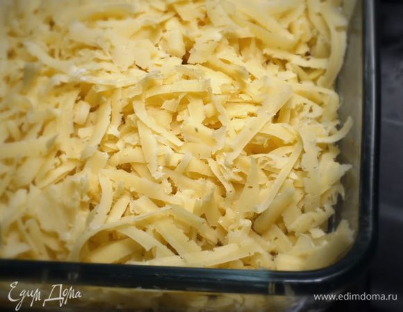 Смесь выложите в огнеупорную форму. Сверху посыпьте тертым на крупной терке сыром. Запекайте в духовке при 180°C 30 минут.