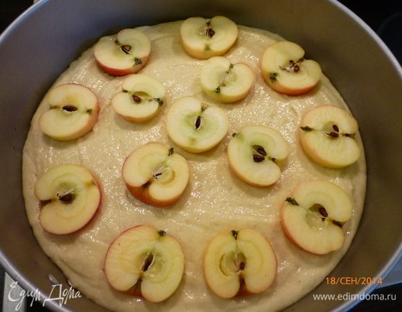 Выливаем тесто в форму ( у меня разъемная, 23 см в диаметре). Поверх выкладываем половинки яблок, слегка вдавливая их.