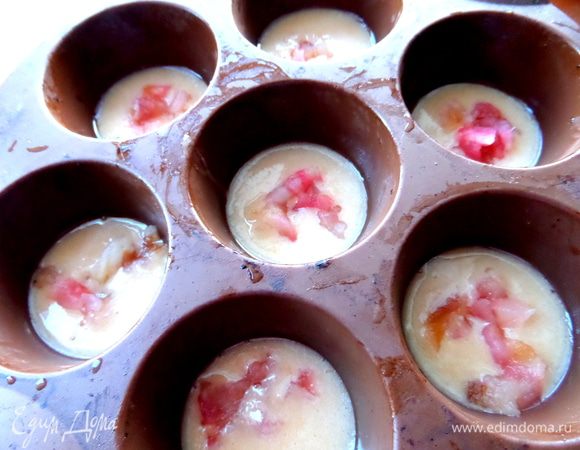 Берём силиконовую форму и наливаем половину теста, сверху в каждую ячейку положим начинку.