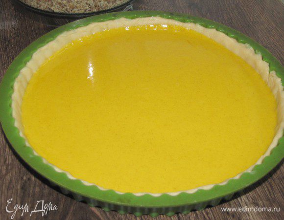 Раскатать тесто в круг по диаметру формы и с помощью скалки перенести его в форму. Сформировать бортики. Наколоть тесто вилкой. Вылить на тесто тыквенную начинку и разровнять.