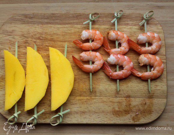 Манго очистить и нарезать ломтиками. Нанизать креветки и ломтики манго на шпажки. 