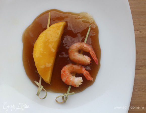 Обмакнуть шпажки с креветками и манго в глазурь и быстро обжарить на гриле до появления карамельных подпалин.

Посыпать розовым перцем и подавать.