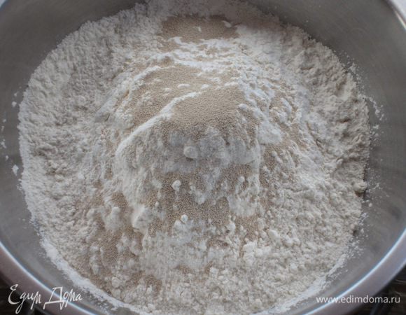 Смешать при помощи миксера муку с сухими дрожжами.
