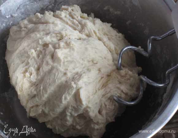 Не выключая миксер, постепенно влить тёплую молочную смесь до получения однородного теста.